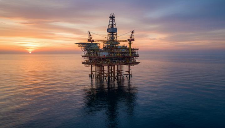 В США обсуждают слияние сланцевых гигантов Devon и Coterra Energy Морская нефтегазовая платформа для добычи углеводородов в открытом море на рассвете.